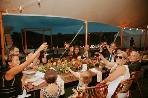 people seated at table raising glasses